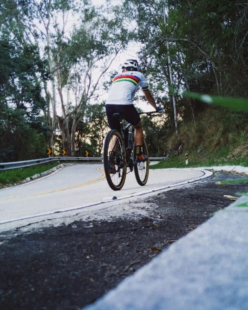 Pacing no ciclismo: ciclista subindo uma estrada sinuosa de montanha